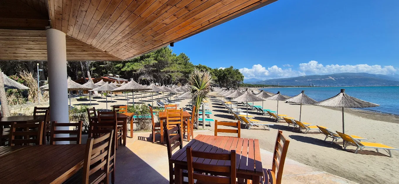Beach front restaurant with sunbeds and parasols overlooking the turquoise sea in Vlora, Albania